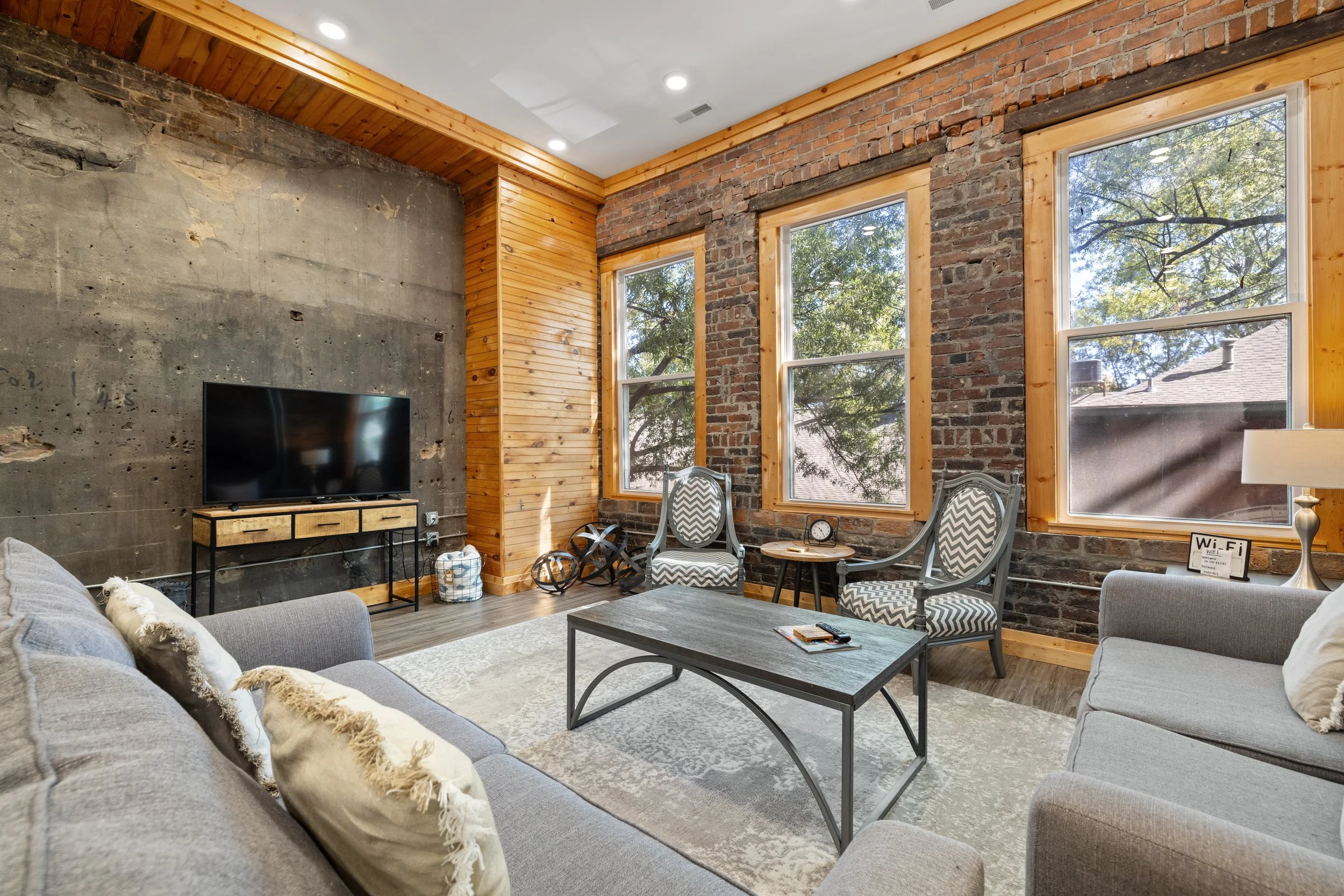Unit 201 — open kitchen and living area with exposed brick